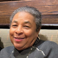 A headshot of a smiling older Black woman with short gray hair.