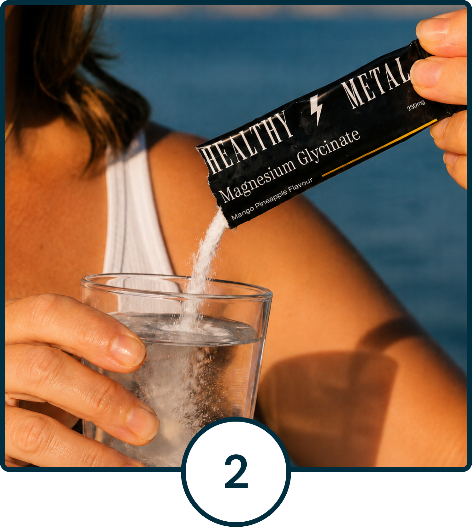 A person pours Healthy Metal Magnesium Glycinate powder from a sachet into a glass of water outdoors.