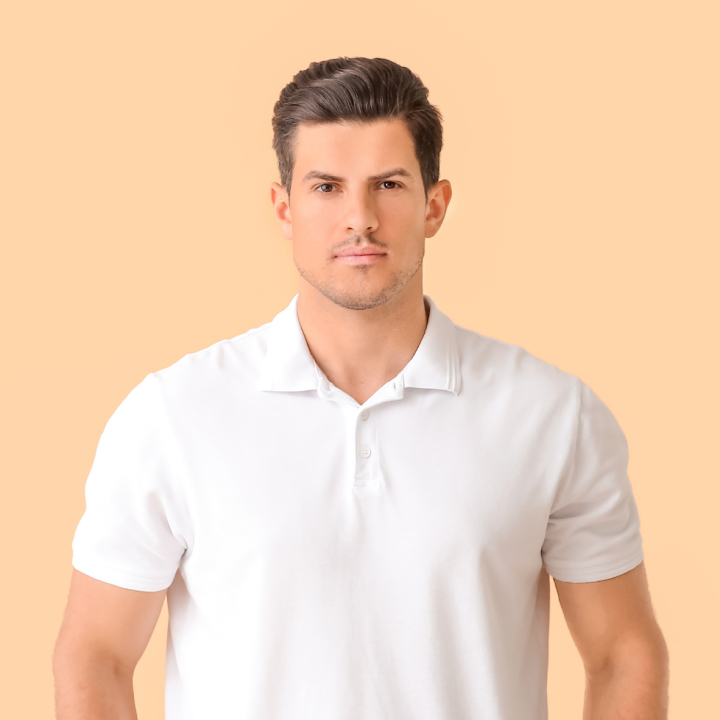 Man in a white polo shirt against a peach background.