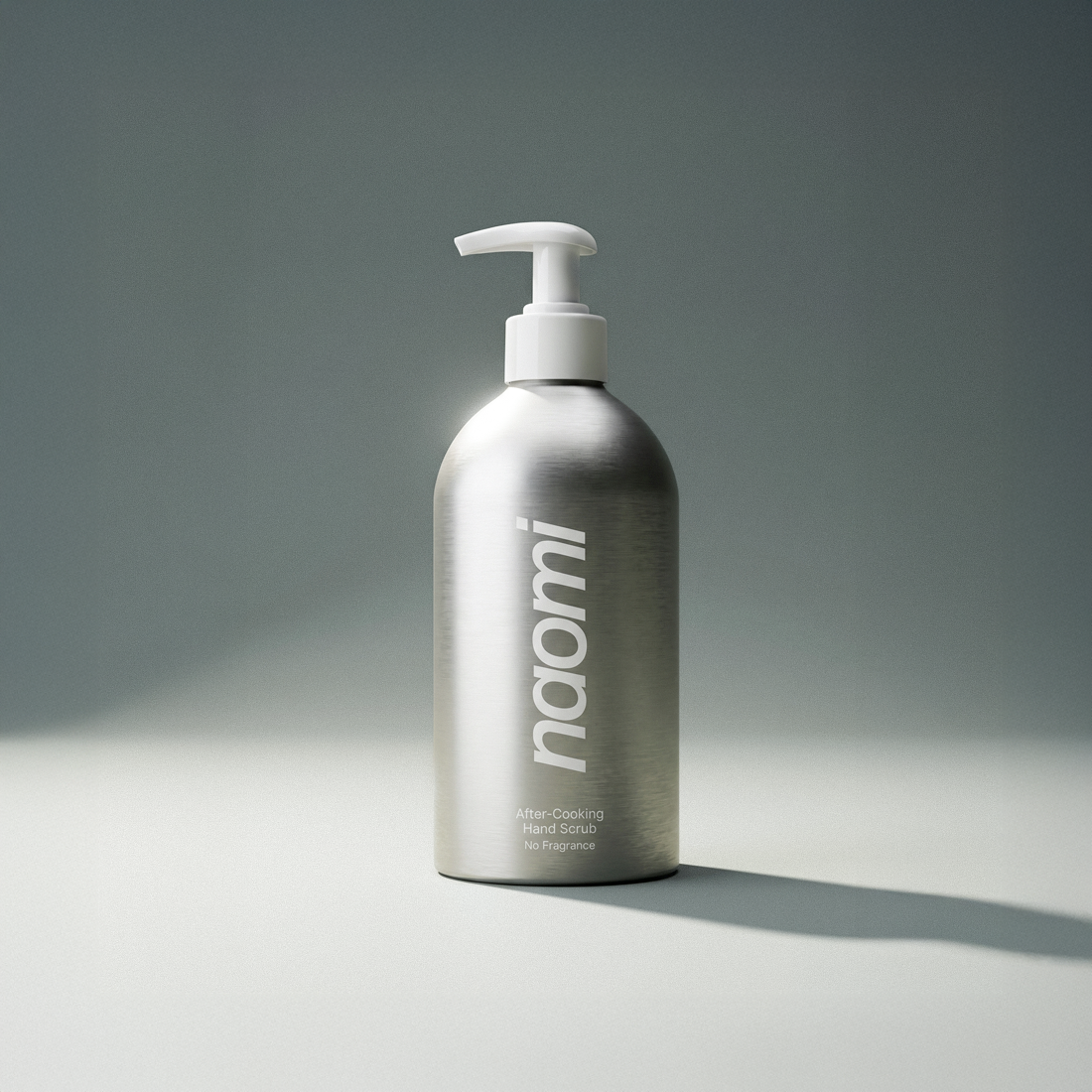 A brushed aluminum pump bottle of Naomi After-Cooking Hand Scrub on a plain surface.
