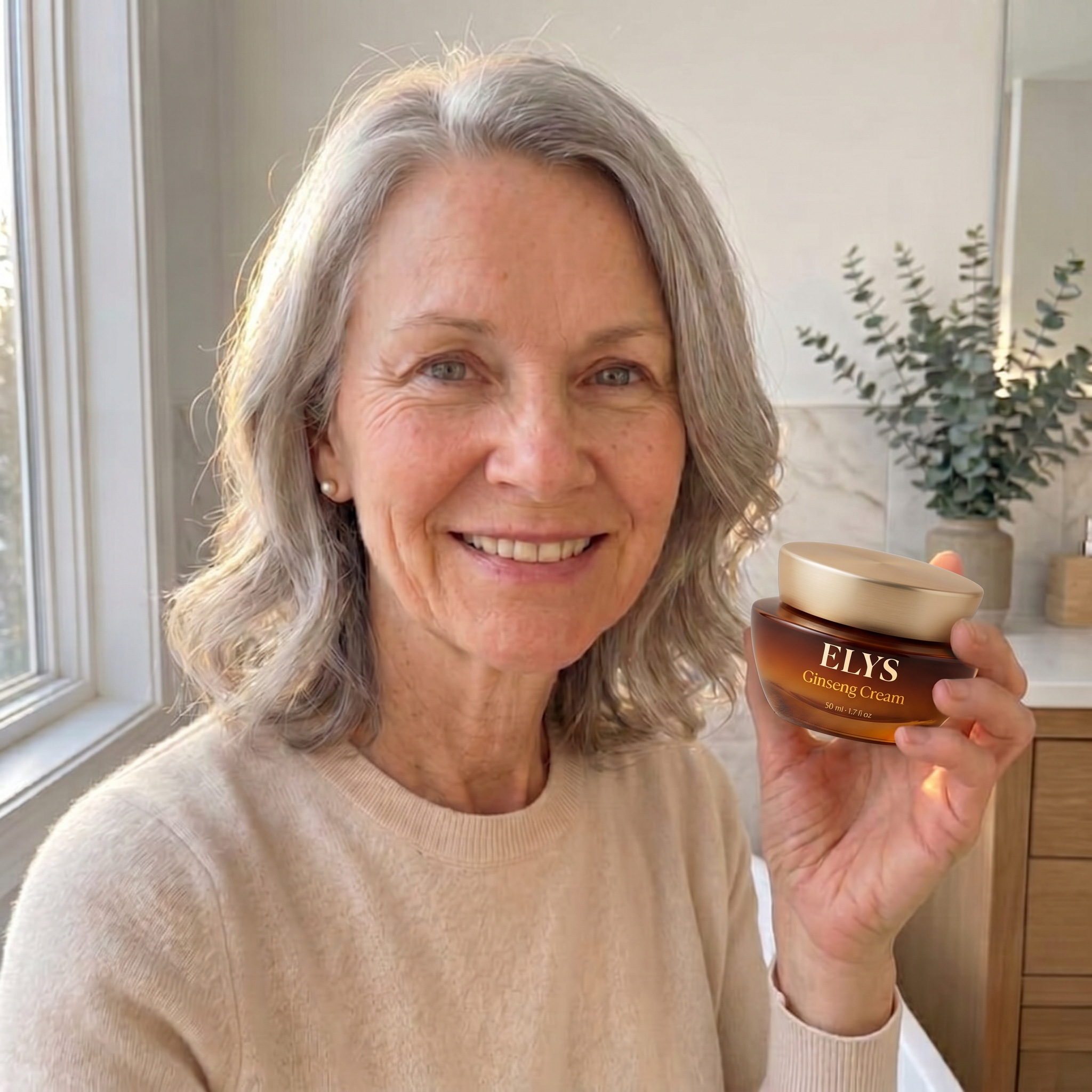 A smiling, gray-haired woman holds up a jar of ELYS Ginseng Cream in a bathroom setting.