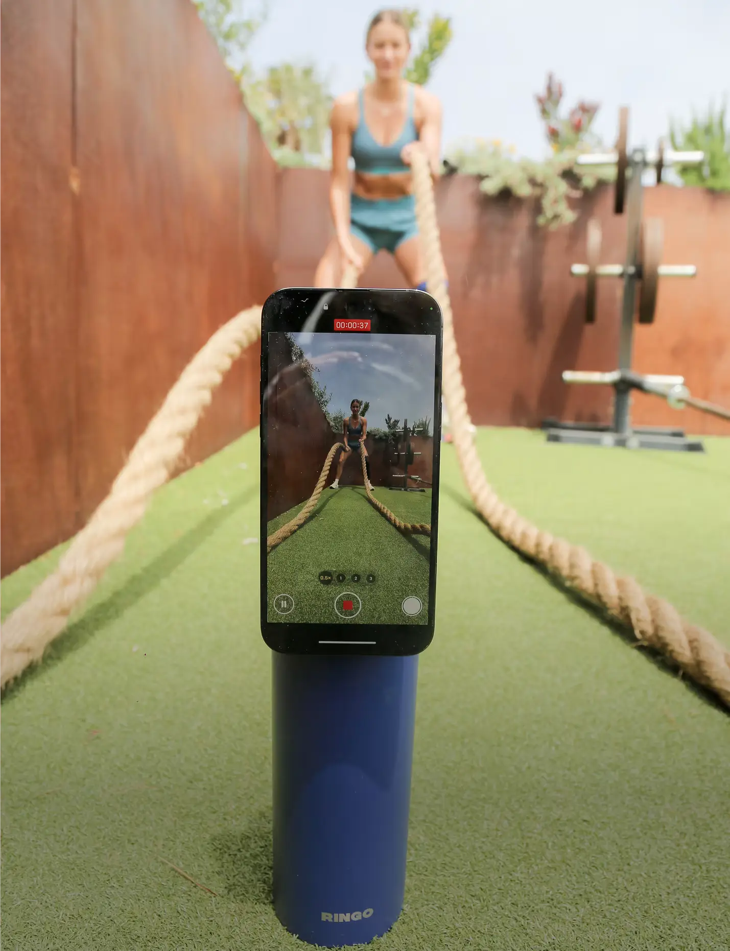 Woman exercising with ropes, filmed on a smartphone.
