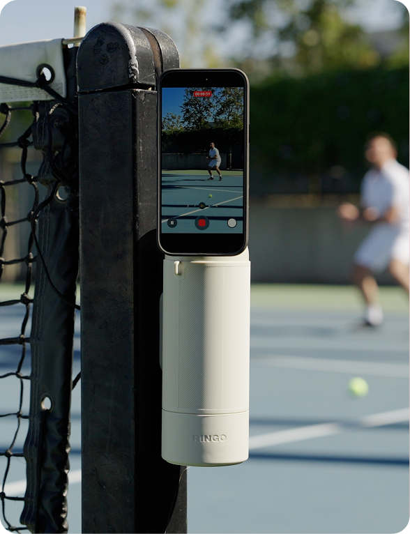 Smartphone mounted on a bottle with a blurred couple in the background.