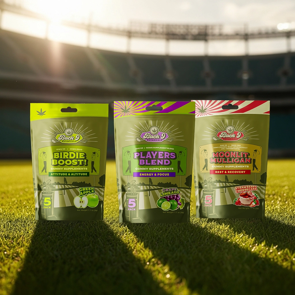 Three packs of gummy supplements on a grass field, under sunlight.