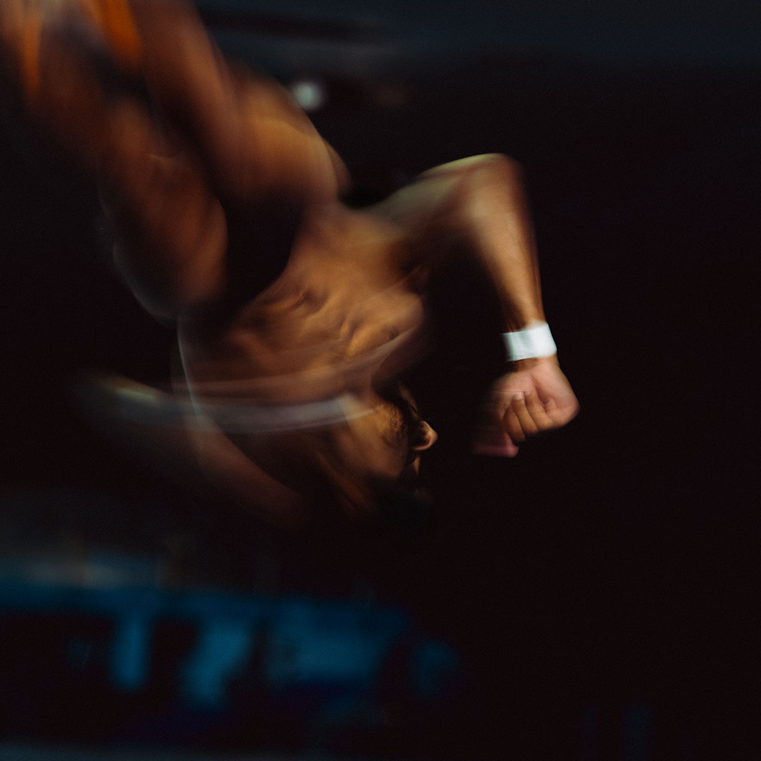 Blurred image of a person in motion against a dark background.