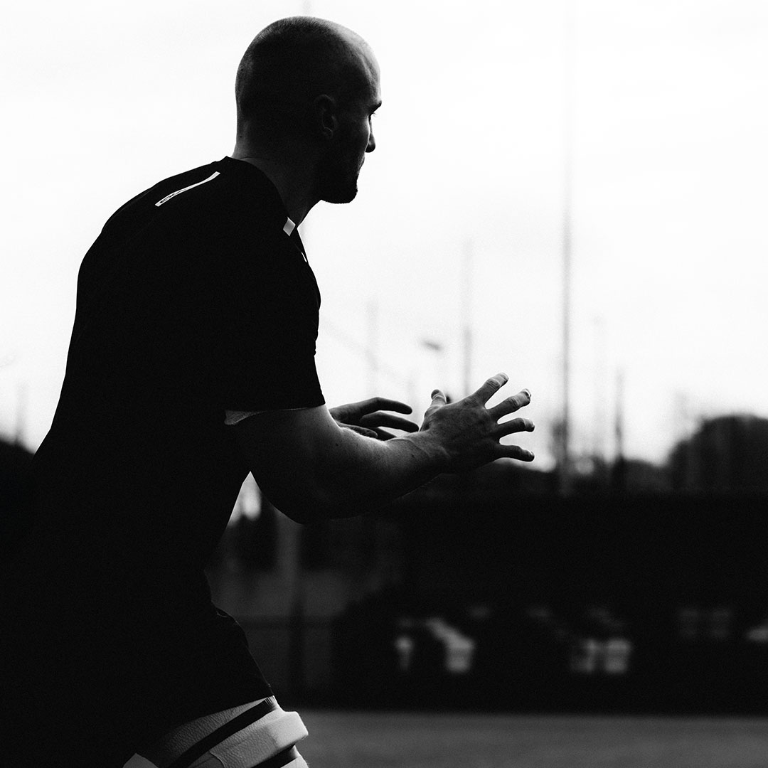 Silhouette of a person in athletic gear on a field.