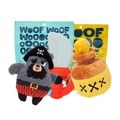  A BarkBox subscription set featuring a plush pirate bear toy, a red squeaky toy, a cupcake-shaped plush toy, and two treat bags with bold 'Woof Woof' packaging.