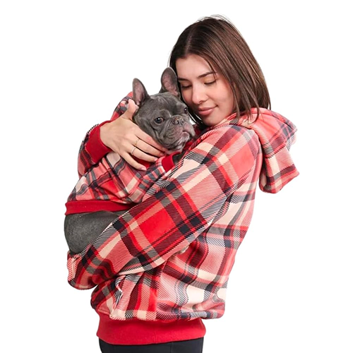 A woman in a red plaid fleece hoodie with a front kangaroo pouch cradling a gray French Bulldog against her chest.