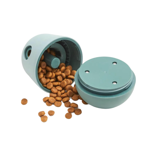 An open, teal-colored pet food dispenser with kibble spilling out against a white background.