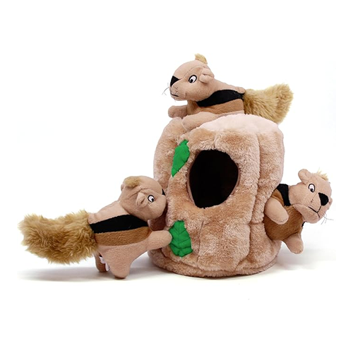 A plush dog toy of a tree stump with three small plush squirrels against a white background.