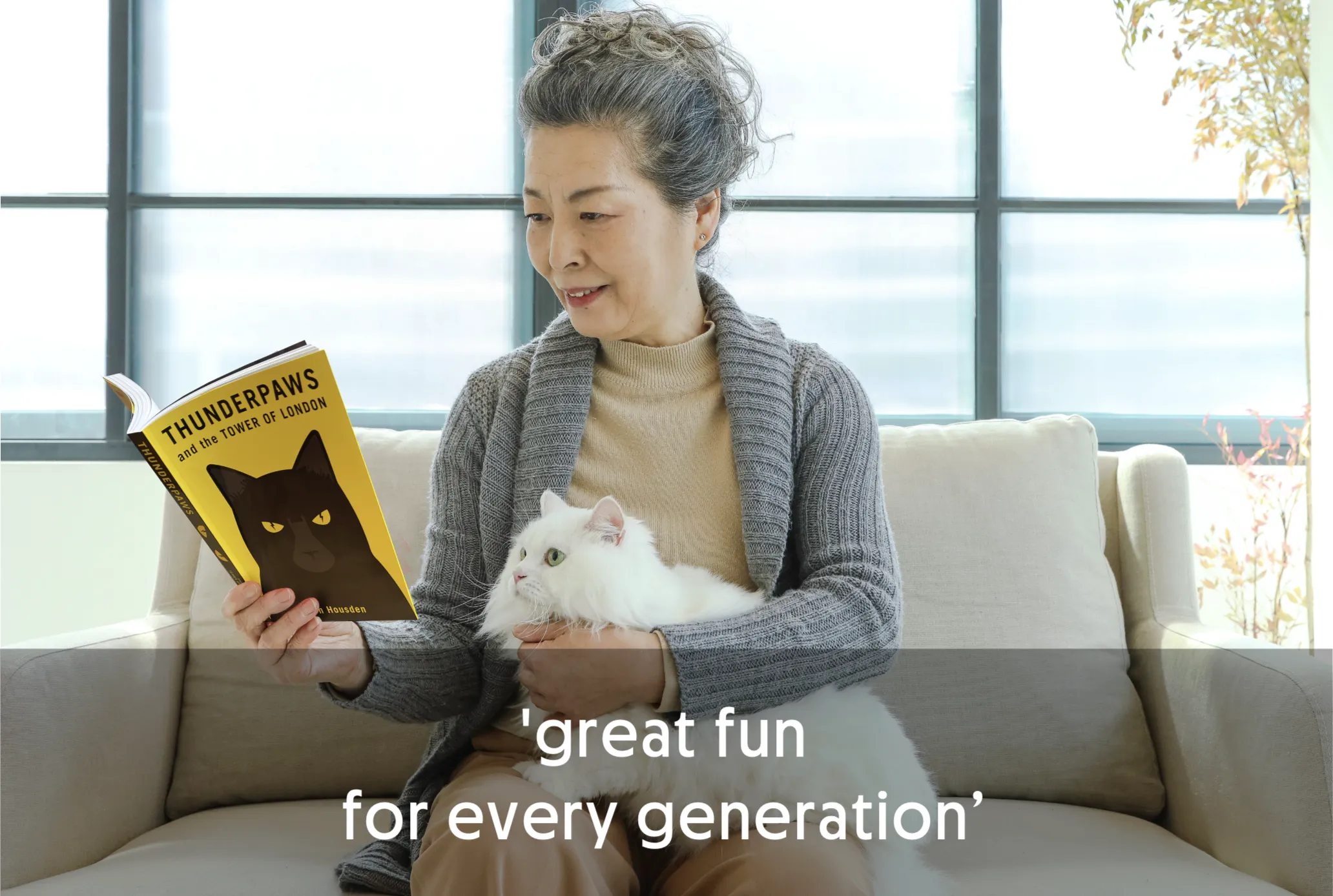 Woman reading a book with a white cat on her lap.