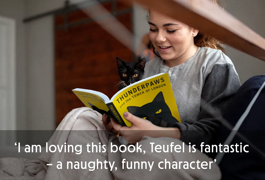 A young woman reading 'Thunderpaws' with a small black cat also looking at the book, with the quote “I am loving this book, Teufel is fantastic – a naughty, funny character.”