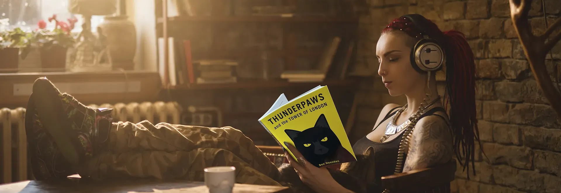 Person with headphones reading a book titled 'Thunderpaws' in a cozy room.
