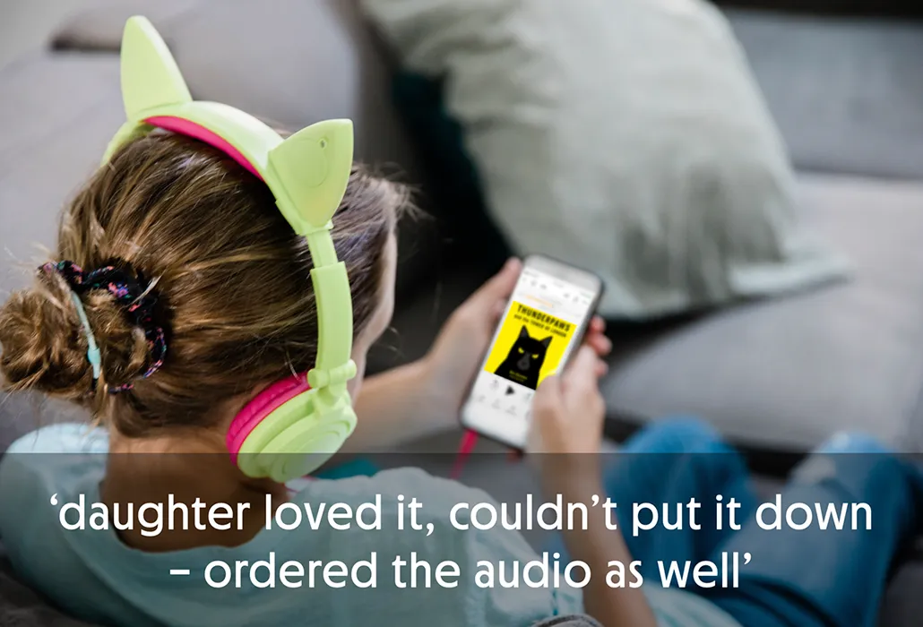 Young girl wearing cat ear headphones, looking at a phone with the audiobook of Thunderpaws on it with the quote “daughter loved it, couldn’t put it down – ordered the audio as well.”