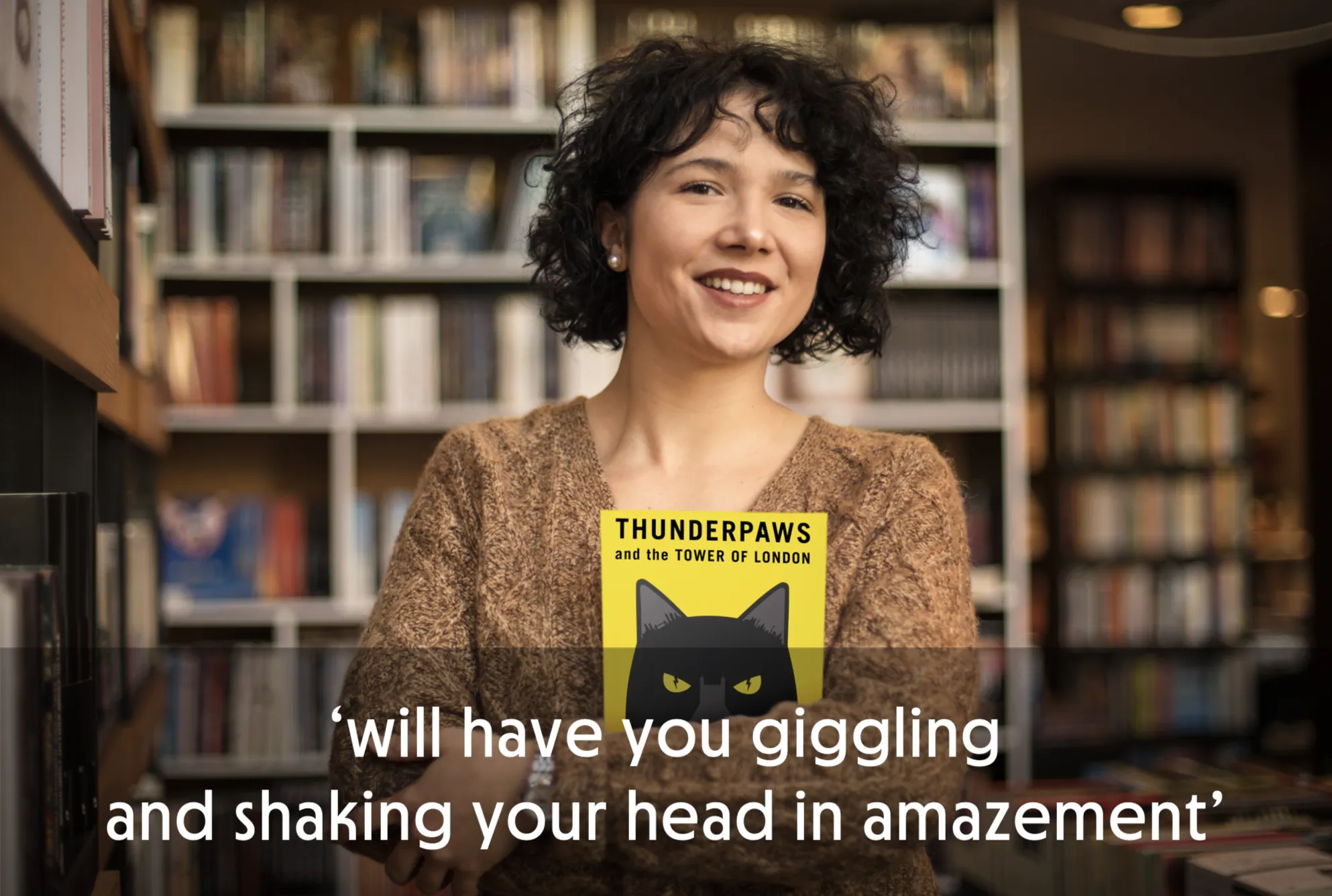 Person holding a book titled 'Thunderpaws and the Tower of London' in a bookstore.