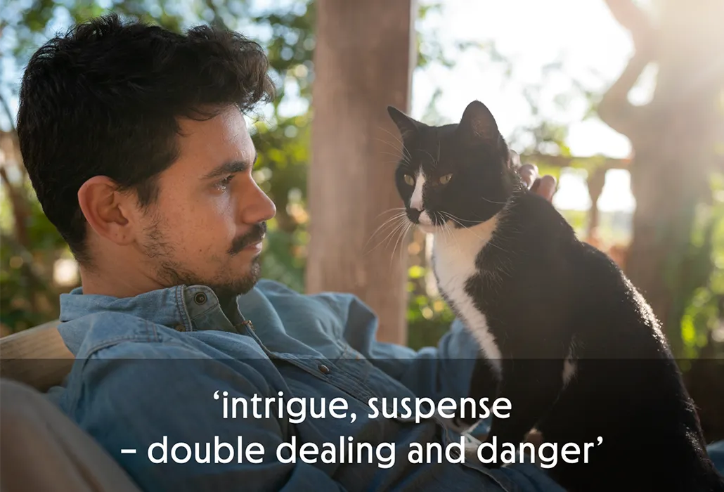 Man looking at a black and white cat say on his lap, with the quote “intrigue, suspense – double dealing and danger.”
