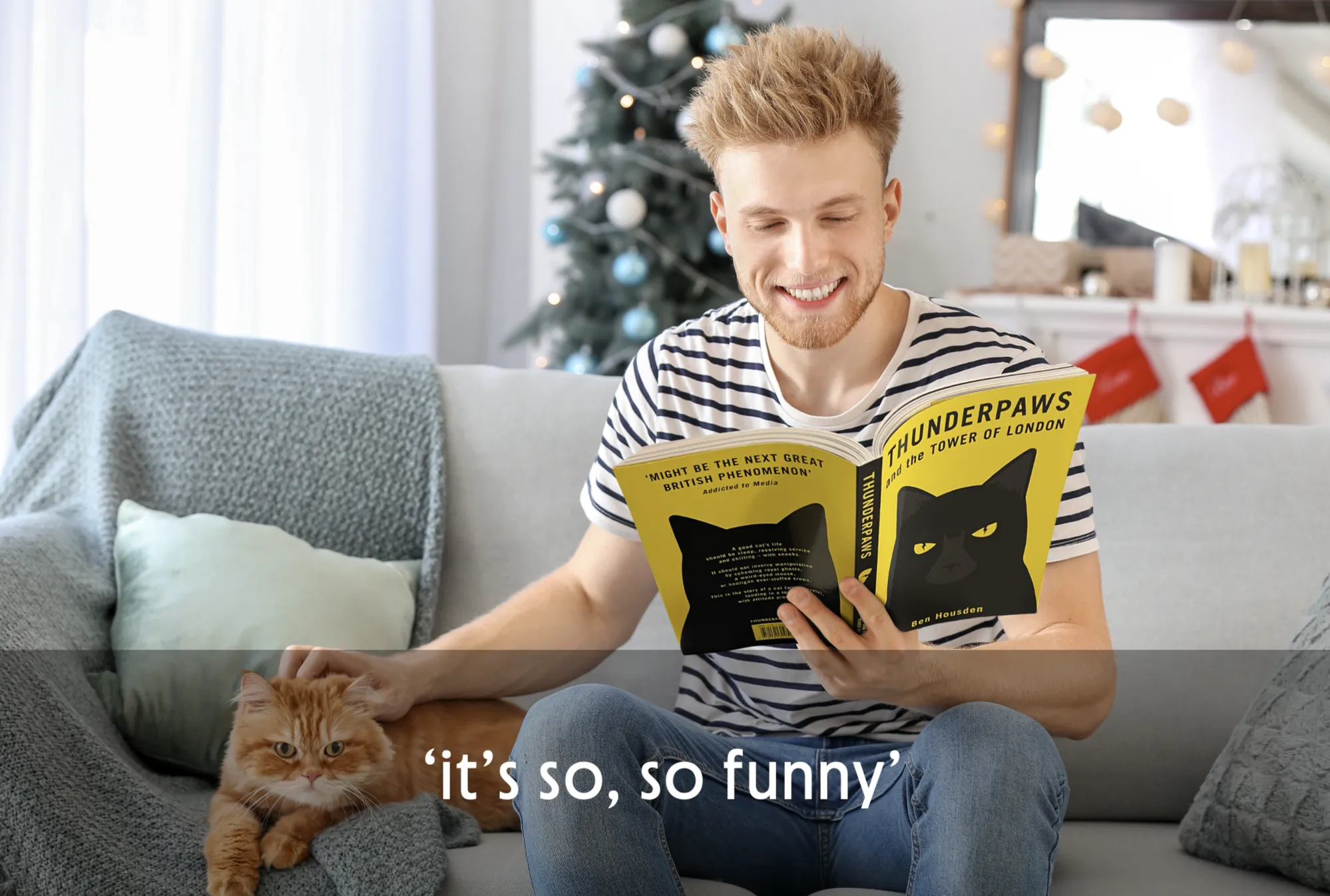 Man reading a book with a cat on his lap, sitting on a couch.