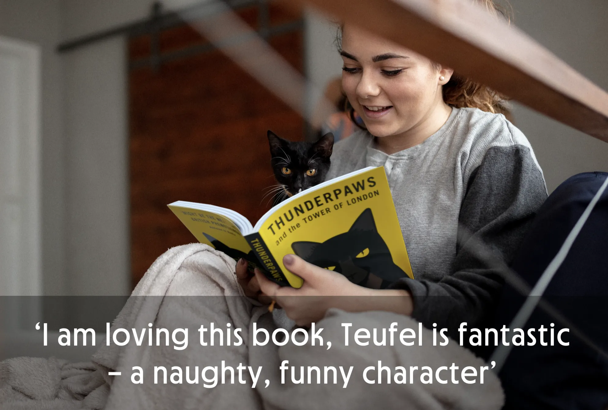 Person reading a book titled 'Thunderpaws' with a black cat on their lap.