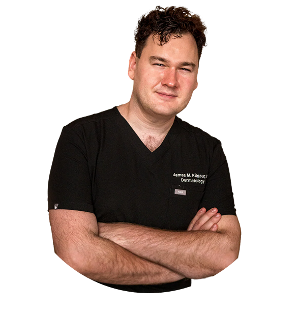 Person in black scrubs with arms crossed, against a white background.