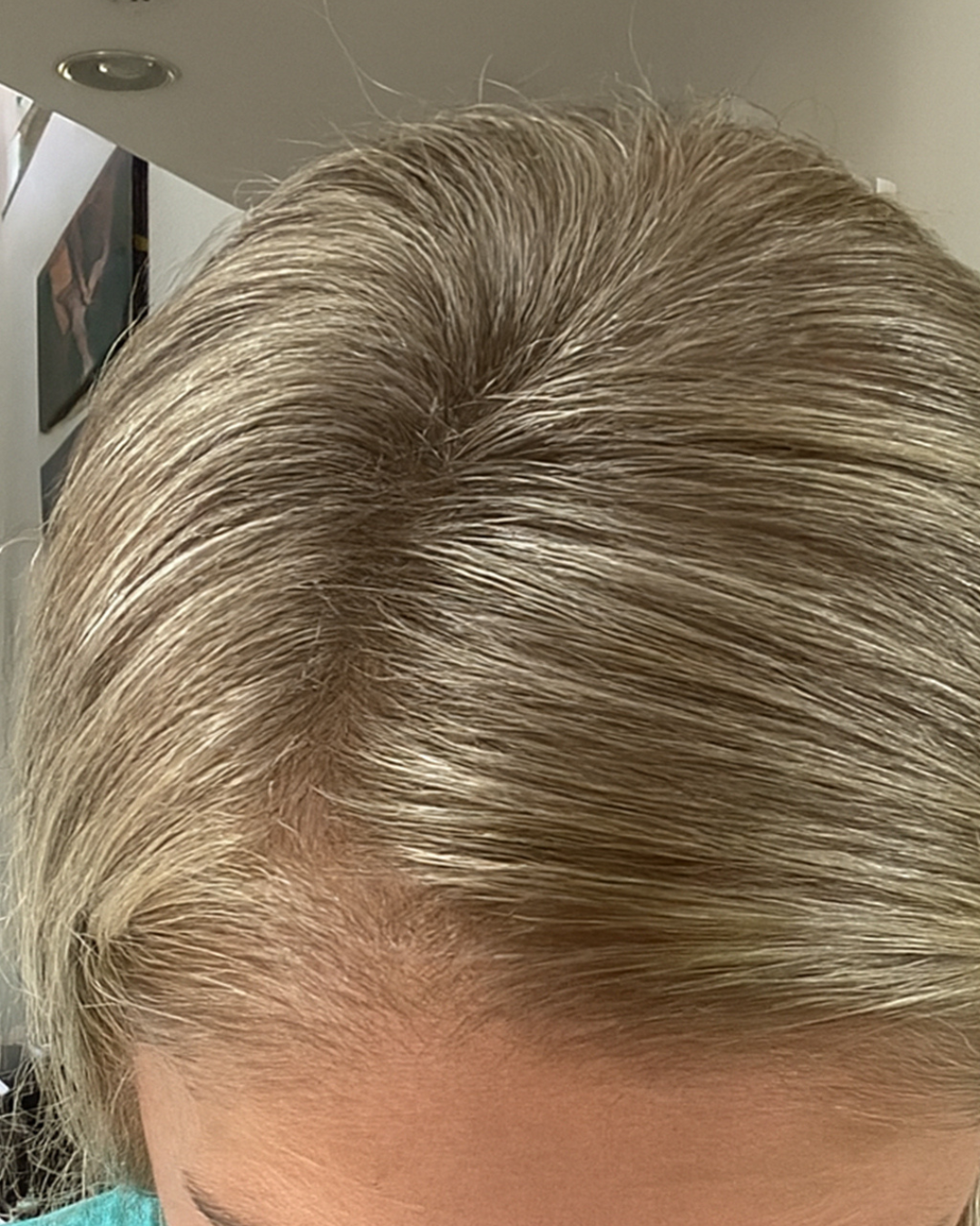 Close-up of a person's light blonde hair from above.