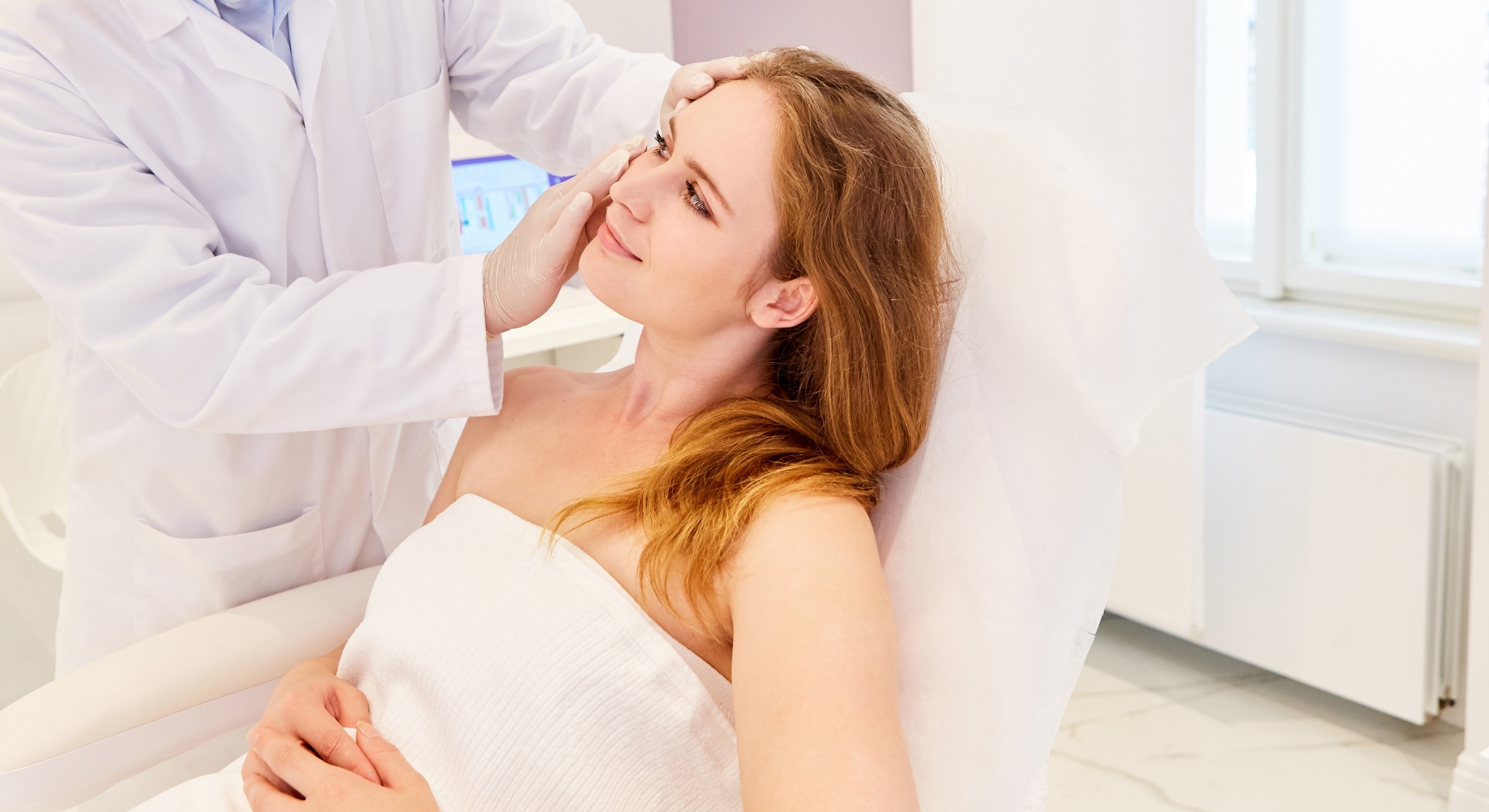 Doctor examining a woman's face in a clinic setting.
