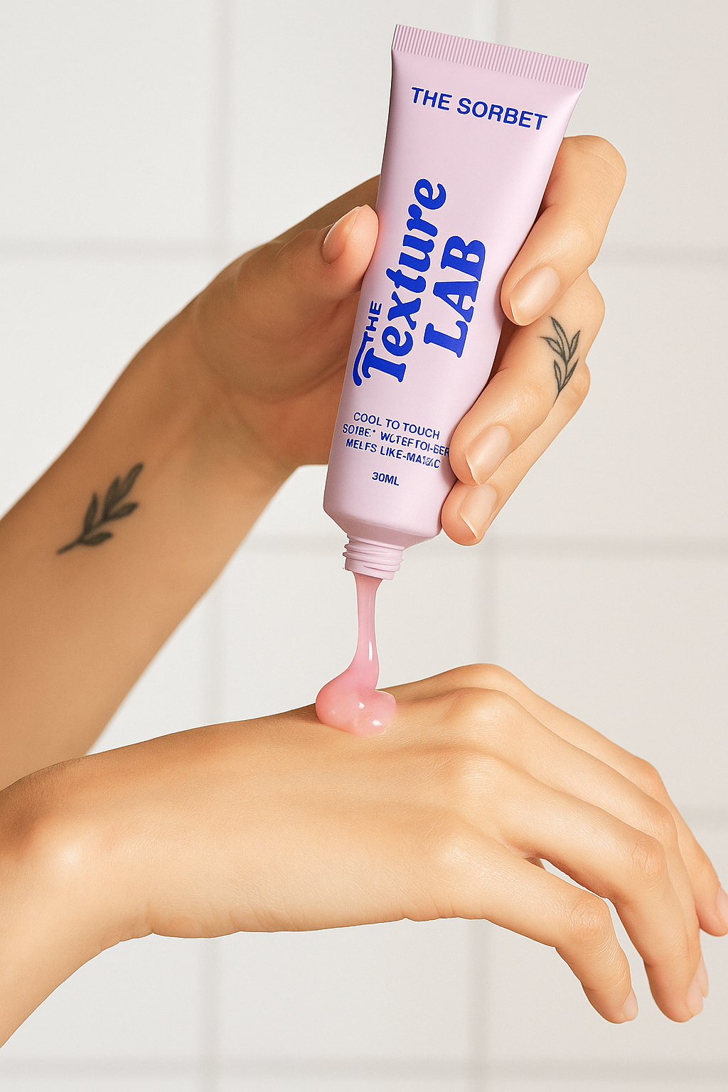 Hand squeezing pink cream from a tube onto another hand.