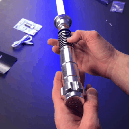 Hands holding a metallic, cylindrical object with grooves and a glowing tip.