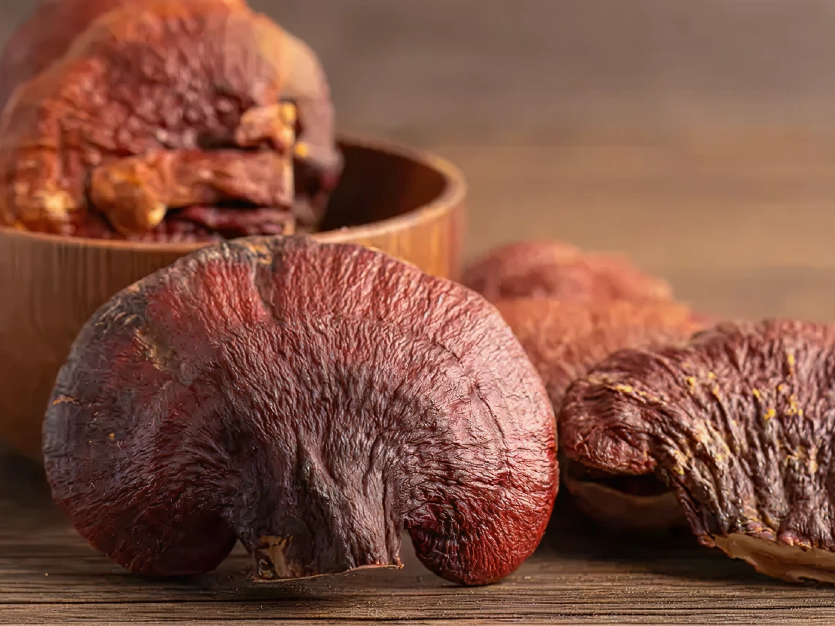 Close-up of several dried mushrooms on a wooden surface.
