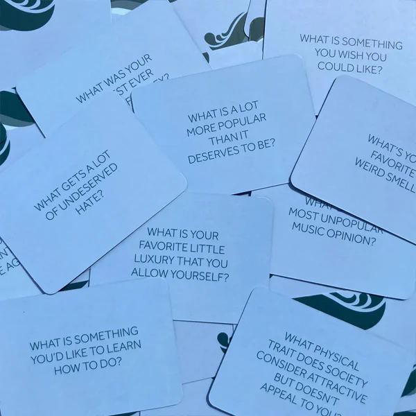 A pile of white cards, each with a different conversation-starting question printed on it.