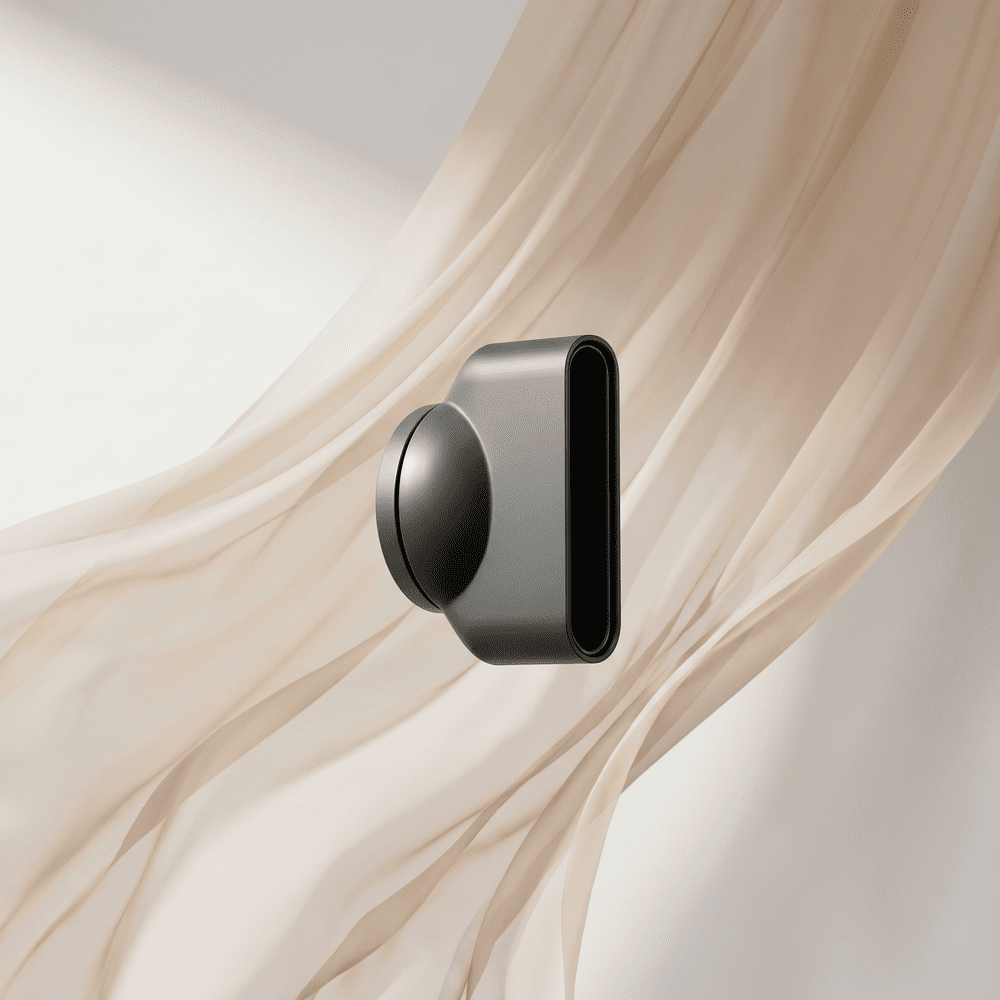 A dark gray hair dryer concentrator nozzle attachment floats in front of a light, flowing fabric.
