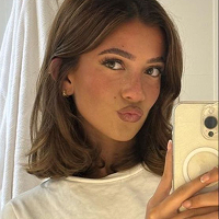 Person taking a mirror selfie with a smartphone, wearing a white shirt.