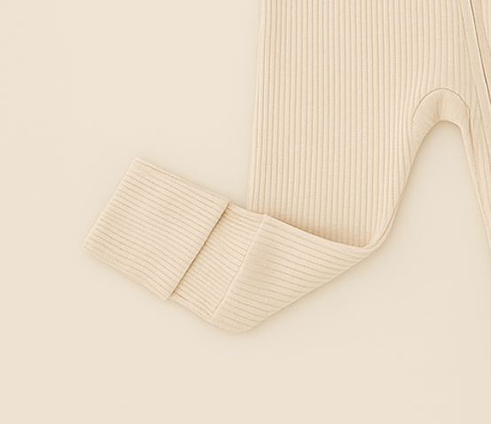 Beige ribbed fabric with a folded edge on a plain background.