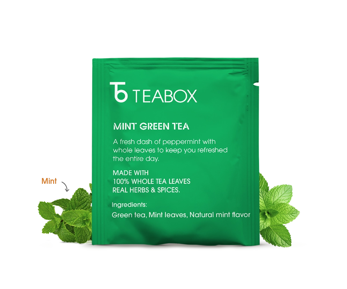 Packaging of Kashmiri Kahwa Saffron Green Tea surrounded by ingredients like cinnamon, cardamom, cloves, almonds, and saffron.