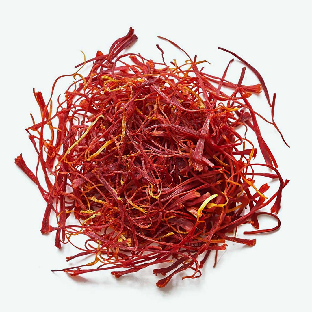 A pile of red saffron threads on a white background.
