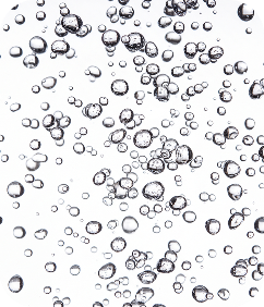 A close-up of many clear bubbles of various sizes against a white background.