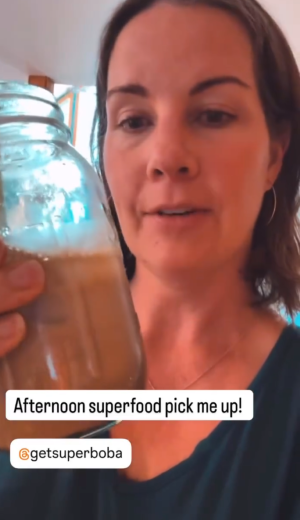 Person holding a jar with a drink, text overlay reads 'Afternoon superfood pick me up!'