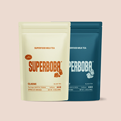 Two Super Boba tea packages, one cream and one blue, on a light background.