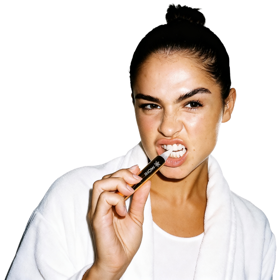 Person in a white robe holding a dental tool with a playful expression.