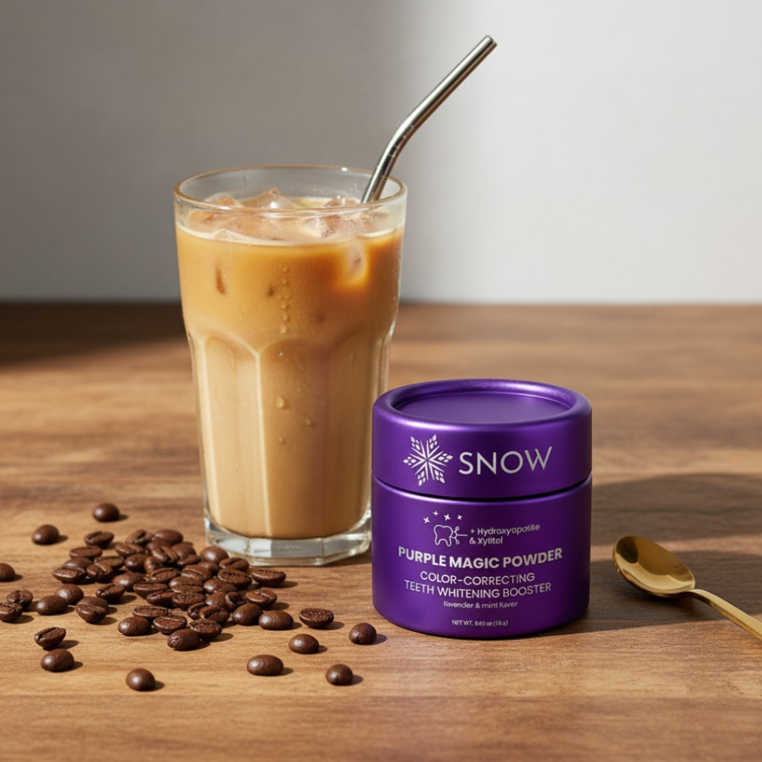 Iced coffee, coffee beans, and a purple container on a wooden surface.