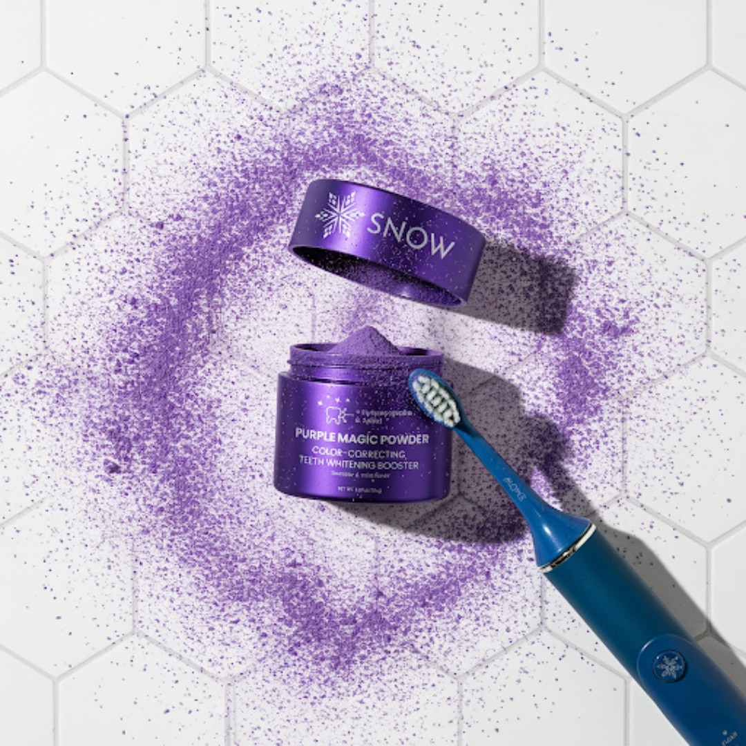 Purple powder with toothbrush and container on hexagonal tiled surface.