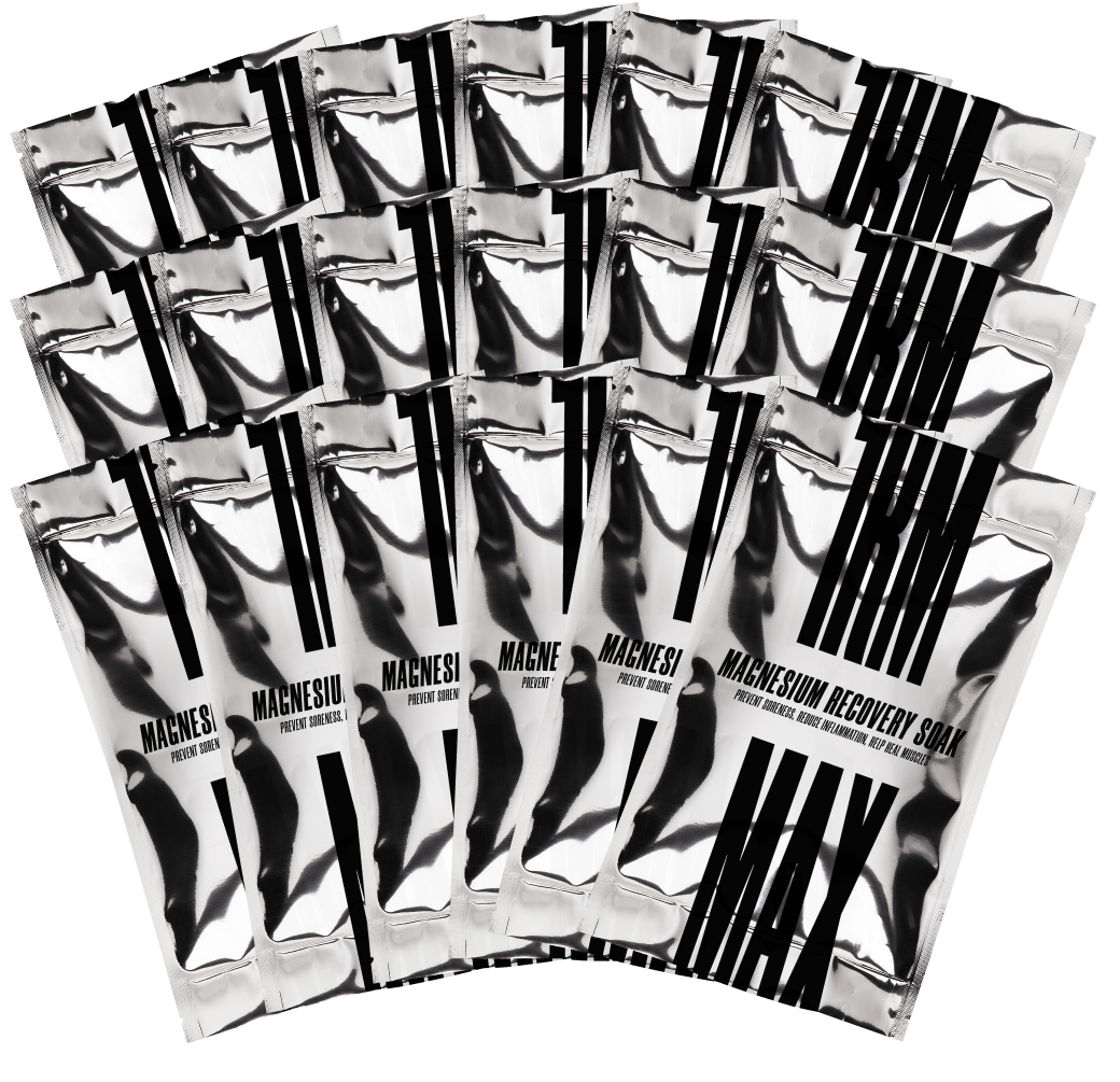 Multiple silver packets of Magnesium Recovery Soak fanned out against a solid black background.