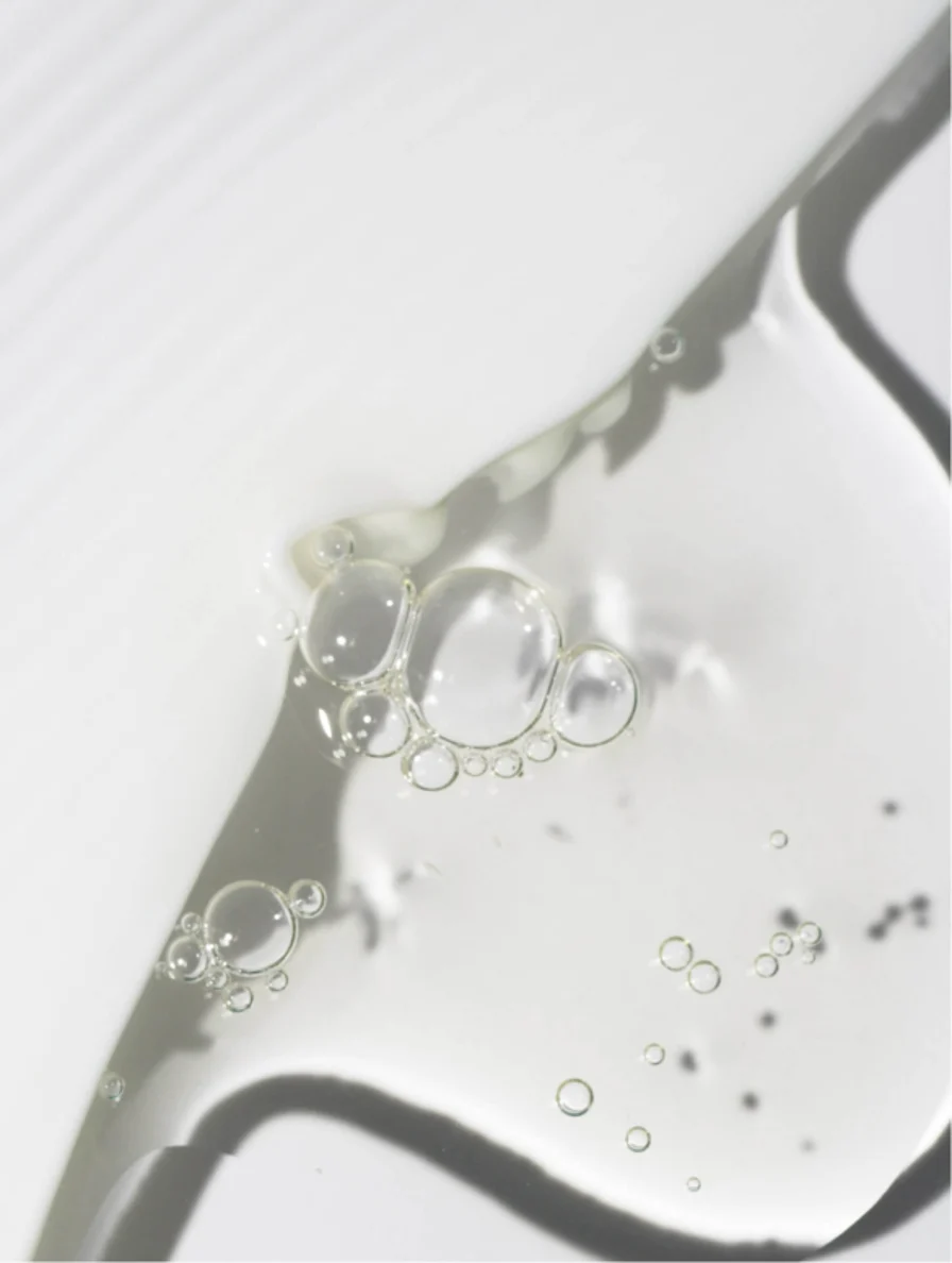 Clear liquid with bubbles on a white surface.