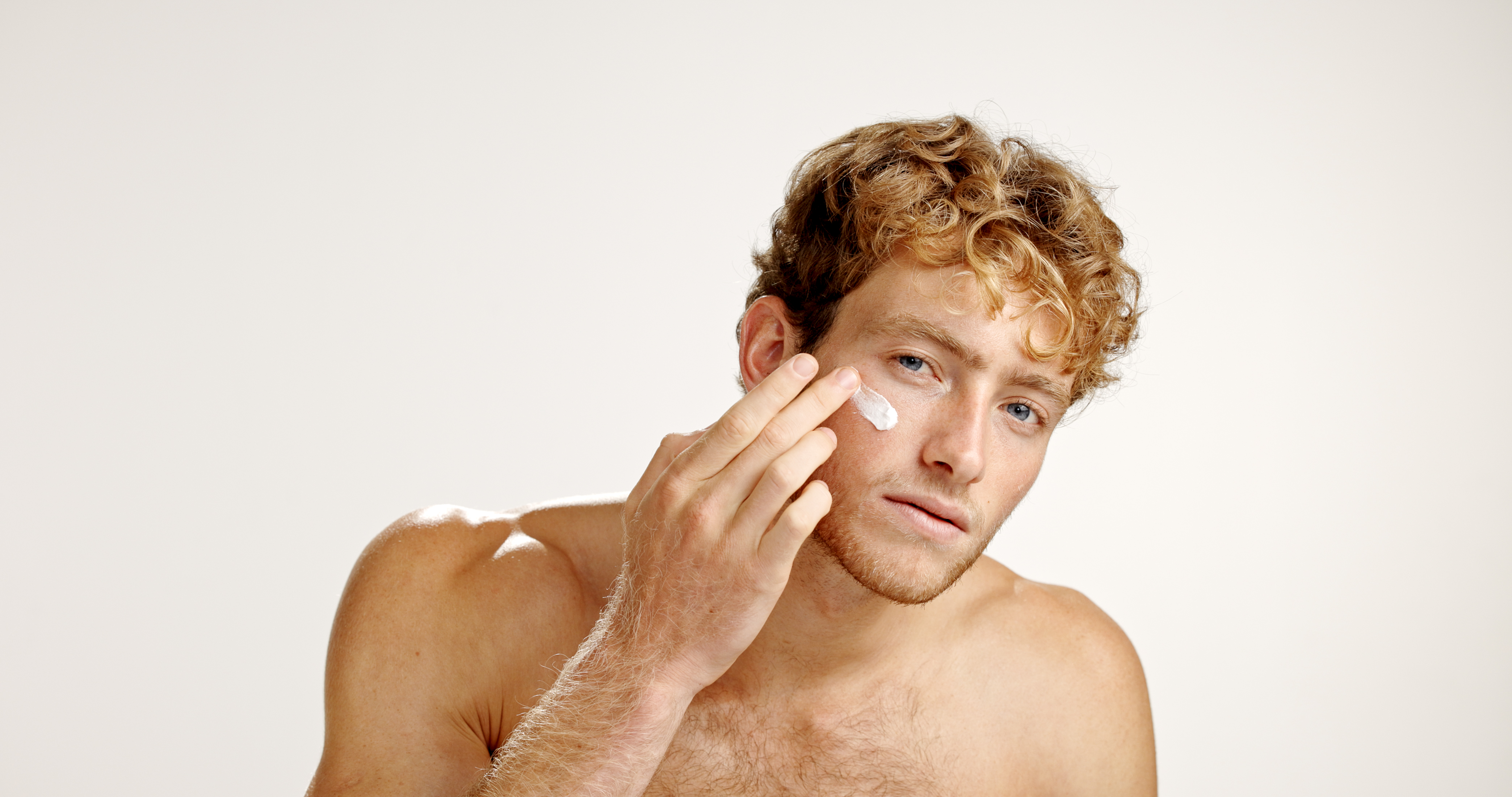 Man applying cream to his cheek.