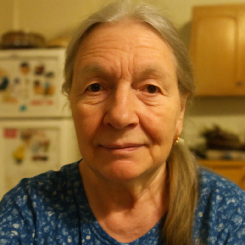 Elderly woman with long gray hair in a kitchen setting.