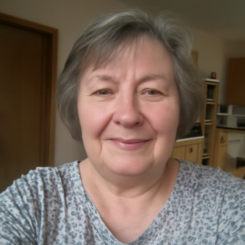 A woman with short gray hair smiling indoors.