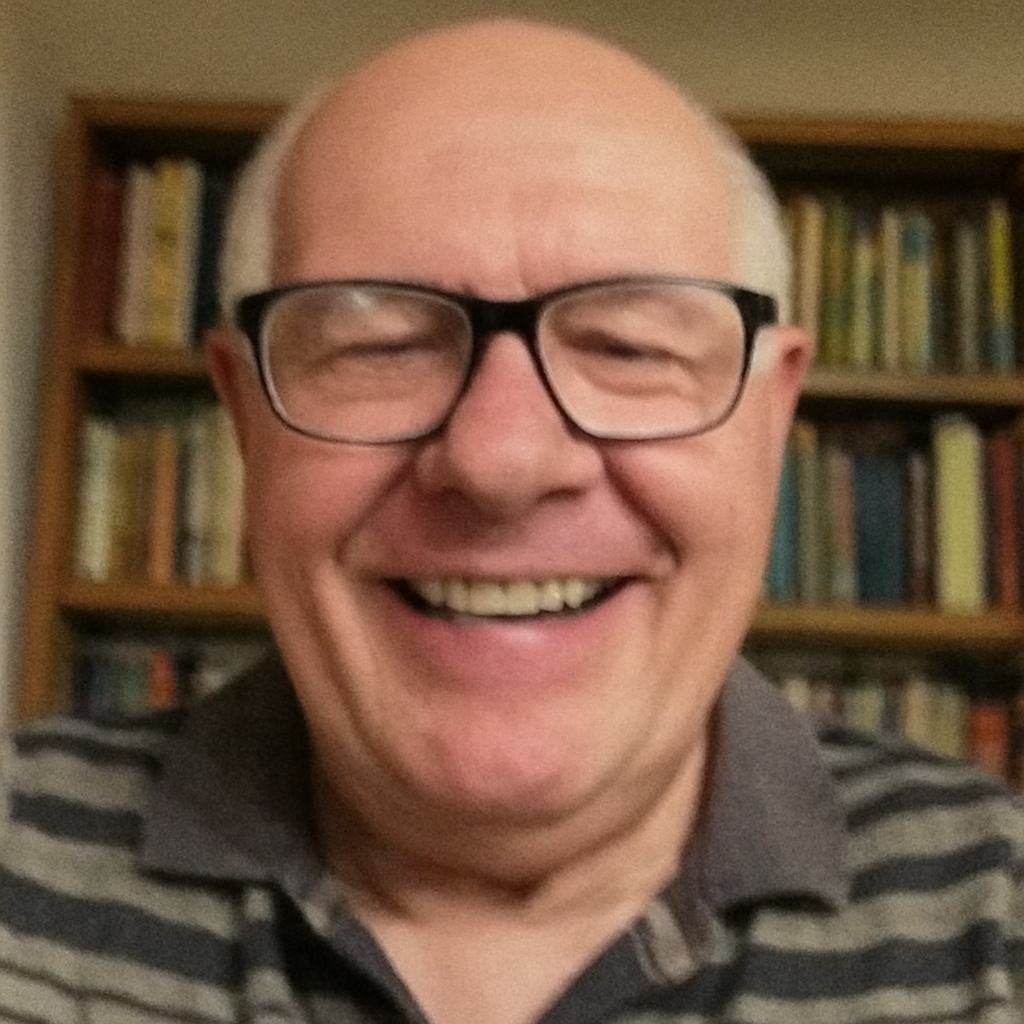 Smiling person wearing glasses in front of a bookshelf.