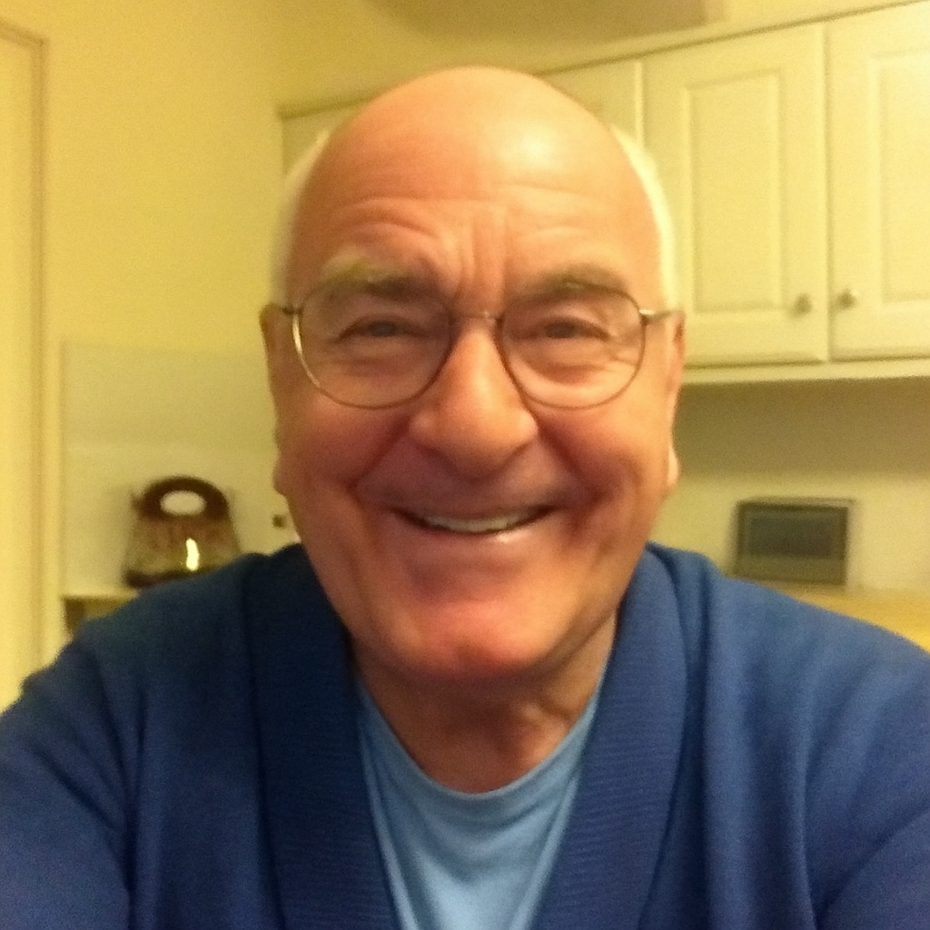 Smiling man with glasses in a kitchen setting.