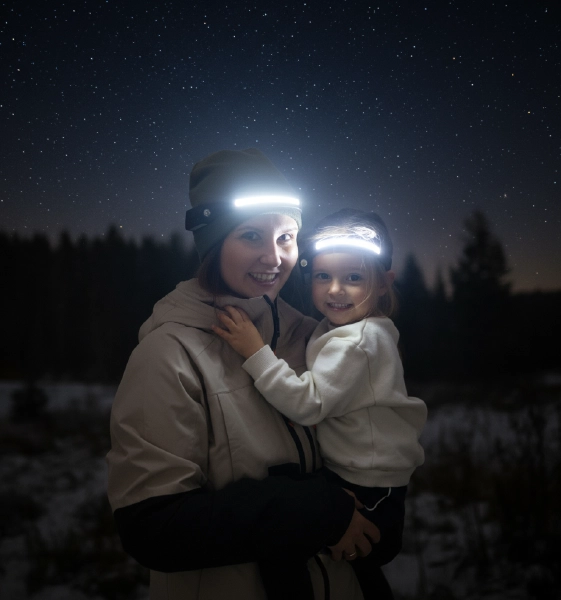 Two people wearing illuminated headbands under a starry night sky.