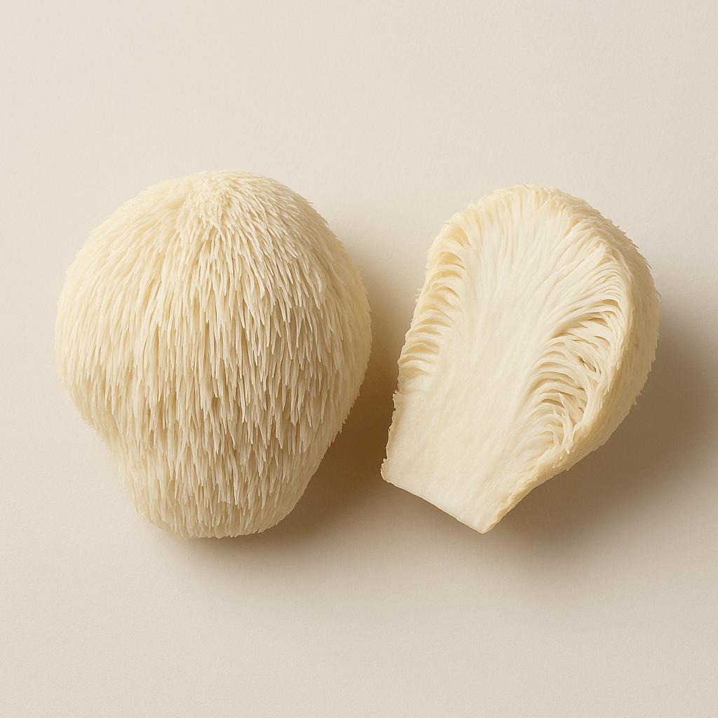 Two pieces of a fluffy, cream-colored mushroom on a light surface.