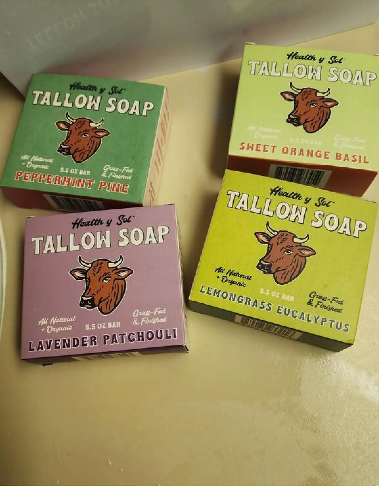 Four boxes of tallow soap in different scents on a table.